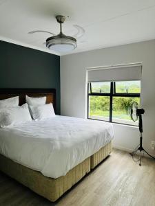 a bedroom with a bed with a fan and a window at Feel at Home Mbombela Self Catering in Nelspruit