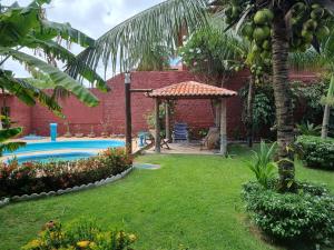 a backyard with a pool and a gazebo at Pousada Casa Típica in São Miguel do Gostoso