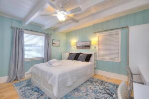 een slaapkamer met een bed en een plafondventilator bij Just Like Paradise in Oak Island
