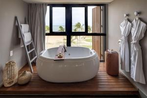 baño con una gran bañera blanca y una ventana en BA'RA Hotel en João Pessoa