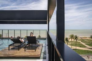 dos personas sentadas en sillas en una terraza cerca de la playa en BA'RA Hotel, en João Pessoa