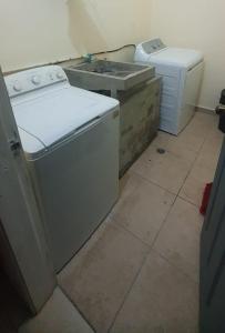 a laundry room with a sink and a washing machine at Refugio Urbano, Res. Uvas Sur in Tegucigalpa