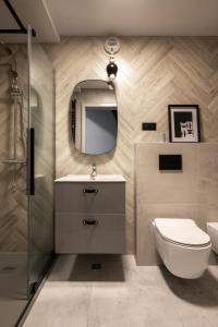 a bathroom with a toilet and a sink and a mirror at Apartamenty Podhale in Zakopane