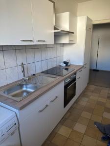 a white kitchen with a sink and a stove at Schönes Apartment in Essen in Essen