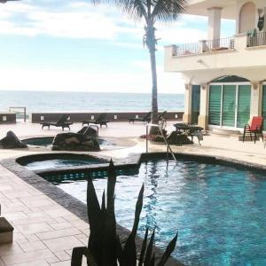 uma piscina com o oceano ao fundo em Ocean Front Condo sleeps 4 - on the Ocean - Marina View- Tiara Sands Resort em Mazatlán