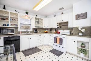 una cocina blanca con armarios y electrodomésticos blancos en Pet Friendly Millcreek Home Close to Downtown/Mtns en Salt Lake City