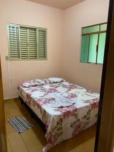 a bedroom with a bed with a floral bedspread at CASA NA SERRA in São Roque de Minas +11 photos