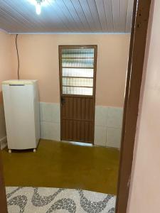 an empty room with a refrigerator and a door at CASA NA SERRA in São Roque de Minas