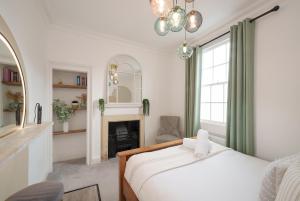 um quarto com uma cama e uma lareira em The Haze House - 4 Bed Townhouse em Bath