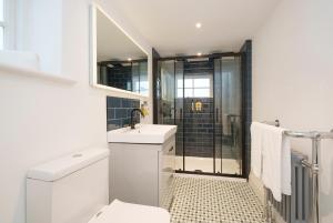 a bathroom with a shower and a toilet and a sink at The Haze House - 4 Bed Townhouse in Bath