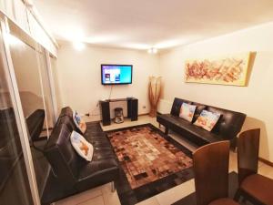 a living room with a couch and a tv at Exclusive Laguna mar- 3 camas matrimonio-10 gente in La Serena