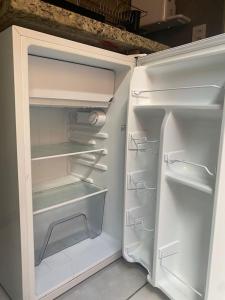 an empty refrigerator with its door open in a kitchen at Top Coliving I in Cuiabá
