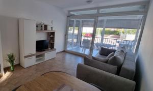 a living room with a couch and a television at Apartmani Sunce i More in Premantura