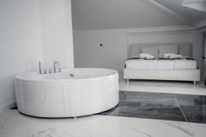 a white bathroom with a tub and a bed at Delago in Ohrid