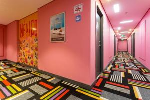 a hallway with pink walls and colorful floors at ibis Styles Sao Paulo Barra Funda in Sao Paulo