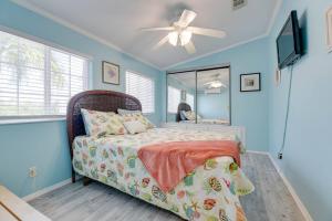 a bedroom with a bed with a ceiling fan and a mirror at Tree Top Paradise in Cudjoe Key