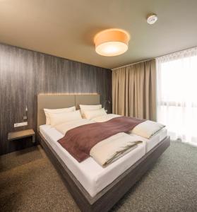 ein Schlafzimmer mit einem großen Bett in einem Zimmer in der Unterkunft MYHOTEL München Olching in Olching