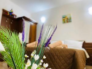 a vase filled with purple and white flowers next to a couch at Studio Elegance Pamporovo in Pamporovo
