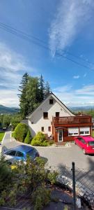 a house with two cars parked in a parking lot at Apartamenty EDEN in Karpacz