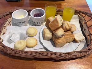 una cesta con un plato de pan y dos vasos de zumo de naranja en Rosadita loft en Río Ceballos