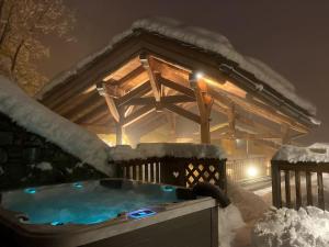 聖福特亨太斯的住宿－chalet ormelune au pied des pistes，雪覆盖的热水浴池和凉亭