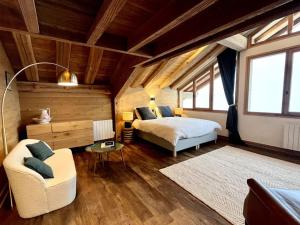 a bedroom with a bed and a chair in a room at chalet ormelune au pied des pistes in Sainte-Foy-Tarentaise