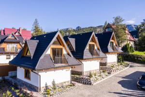 une rangée de maisons aux toits noirs dans l'établissement FILIPOWE CHATY, à Kościelisko