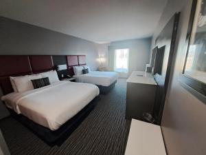 Un pat sau paturi într-o cameră la Del-Mar Airport Inn & Suites