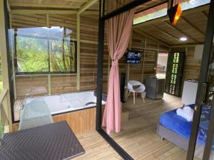 Cette chambre dispose d'une baignoire, d'un lit et d'une fenêtre. dans l'établissement CRISTALES DEL RIO RESORT, à San Rafael