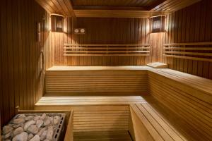 a sauna with wooden walls and wooden floors and a tub at Hotel City Pleven in Pleven
