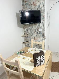 a dining room table with a television on a wall at Casa Della Felicità in Naples