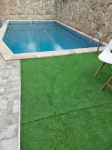 a swimming pool with green grass in a backyard at Apartamento cercano a IFEMA, Aeropuerto, Clinica Universitaria Navarra y Civitas Metropolitano in Madrid