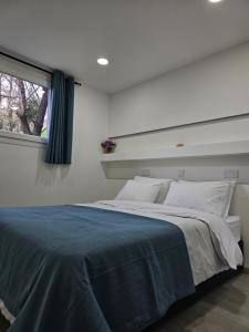 sypialnia z dużym łóżkiem i oknem w obiekcie THE CLIFF ALONA w mieście Alona