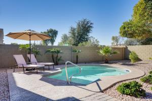 uma pequena piscina com uma mesa e cadeiras e um guarda-sol em Goodyear Home with Pool, 6 Mi to Spring Training! em Goodyear