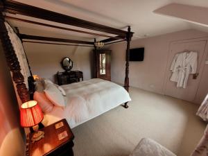 a bedroom with a large white bed and a dresser at Burton Grange Farmhouse Bed and Breakfast in Boroughbridge