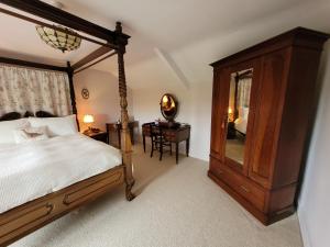 a bedroom with a bed and a dresser and a mirror at Burton Grange Farmhouse Bed and Breakfast in Boroughbridge