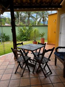 einen Tisch und Stühle auf einer Terrasse in der Unterkunft Linda casa em condomínio in Paraty