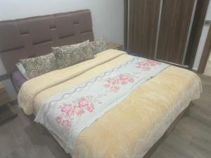 duże łóżko w sypialni z kwiatami w obiekcie Appart Kech Menera w Marakeszu