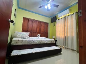 1 dormitorio con 2 camas y ventilador de techo en Posada Faych House en San Andrés