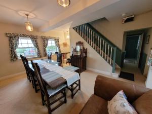 a dining room with a table and a couch at Burton Grange Farmhouse Bed and Breakfast in Boroughbridge