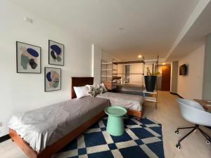 um quarto com 2 camas, uma secretária e uma cadeira em Stylish and Cozy Apartment in Heart of Guatemala BEITA em Guatemala