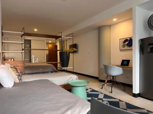 a hotel room with two beds and a desk and a bed at Stylish and Cozy Apartment in Heart of Guatemala BEITA in Guatemala