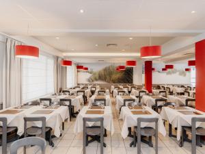 a dining room with white tables and chairs at Domein Westhoek in Oostduinkerke