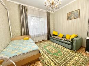 uma sala de estar com um sofá e almofadas amarelas em Spacious and cozy villa em Bishkek