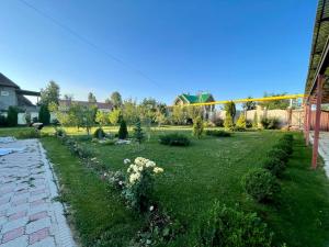 a garden with flowers in the middle of a yard at Spacious and cozy villa in Bishkek