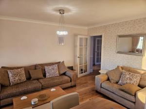 a living room with two couches and a table at Meadow View in Haverfordwest