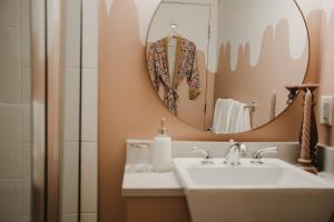 uma casa de banho com um lavatório e um espelho em The Garden Room at Waddington Flats em Victoria