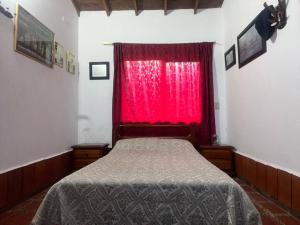 una camera con un letto e una finestra rossa di Green farm, with dry/wet, and near infrared sauna a Caldas