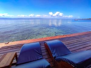 a pair of blue chairs sitting on a wooden deck at Bahia Coral Lodge in Bocas Town
