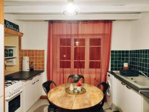 uma cozinha com uma mesa com cadeiras e uma janela em Charmant studio tout équipé em Olliergues